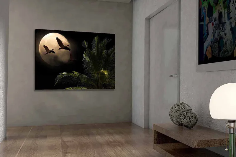 Canvastavla 70x100 cm - Två fåglar som flyger mot en stor måne över en palmliknande växt, Mörkgrön / Grå / Beige