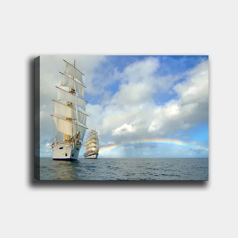 Canvastavla 70x100 cm - Två segelbåtar som navigerar genom ett lugnt hav under en blå himmel med moln och en regnbåge, Vit / Blå / Grå
