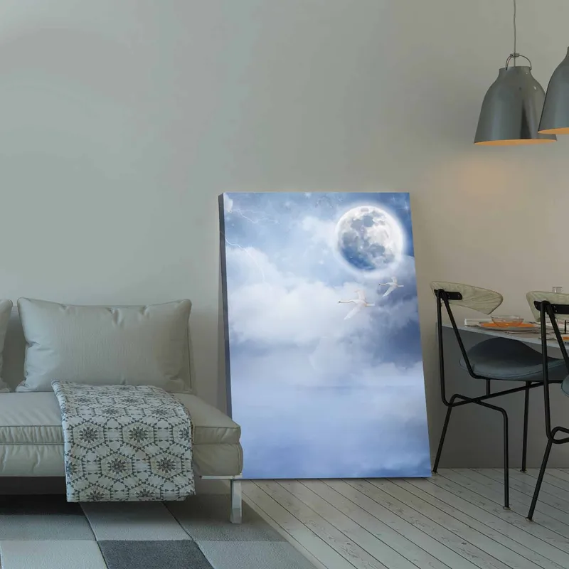 Canvastavla 70x100 cm - Två svanar som flyger under en stor måne i en drömlik, molnig himmel - Ljusblå / Vit / Mörkblå - Inredning - Tavlor & konst - Canvastavlor