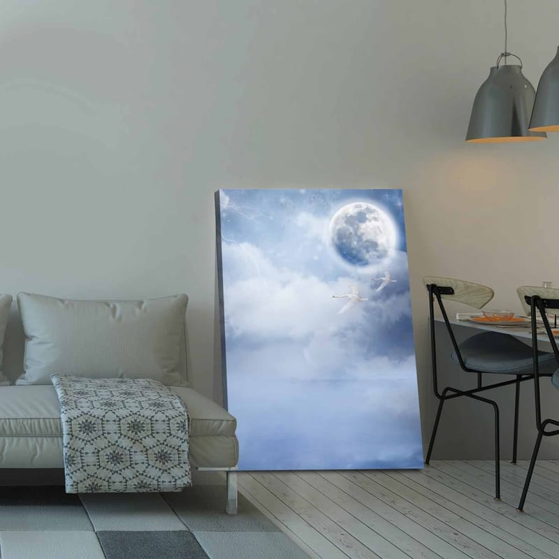 Canvastavla 70x100 cm - Två svanar som flyger under en stor måne i en drömlik, molnig himmel - Ljusblå / Vit / Mörkblå - Inredning - Tavlor & konst - Canvastavlor