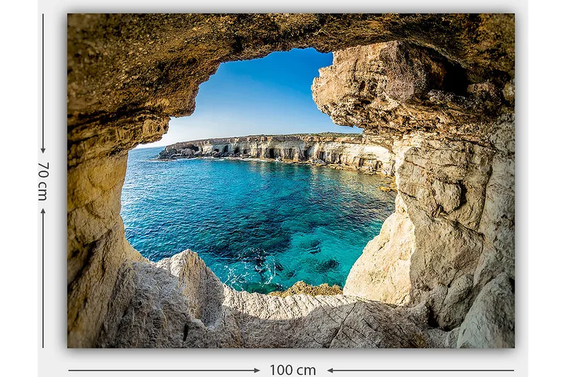 Canvastavla 70x100 cm - Utsikt genom en klippöppning mot en klarblå havsstrand - Blå / Beige / Vit - Inredning - Tavlor & konst - Canvastavlor
