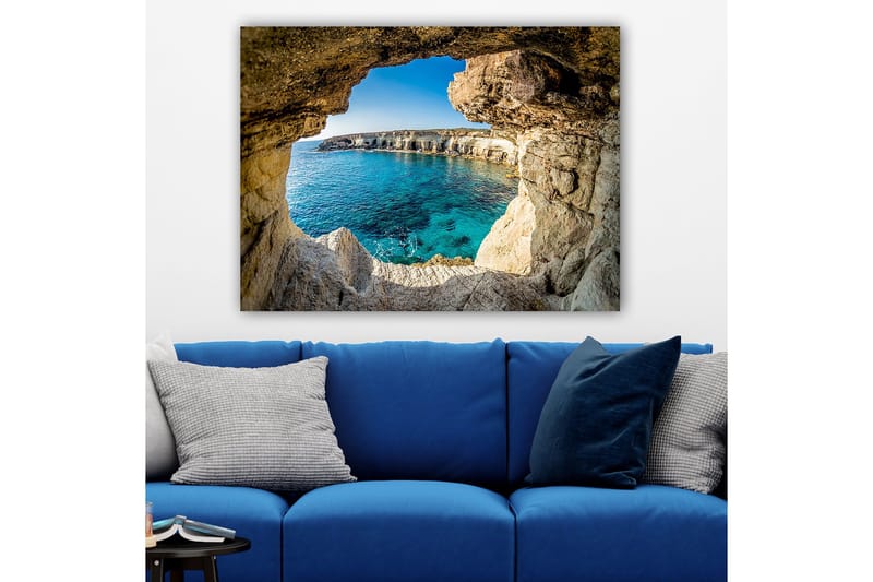 Canvastavla 70x100 cm - Utsikt genom en klippöppning mot en klarblå havsstrand - Blå / Beige / Vit - Inredning - Tavlor & konst - Canvastavlor