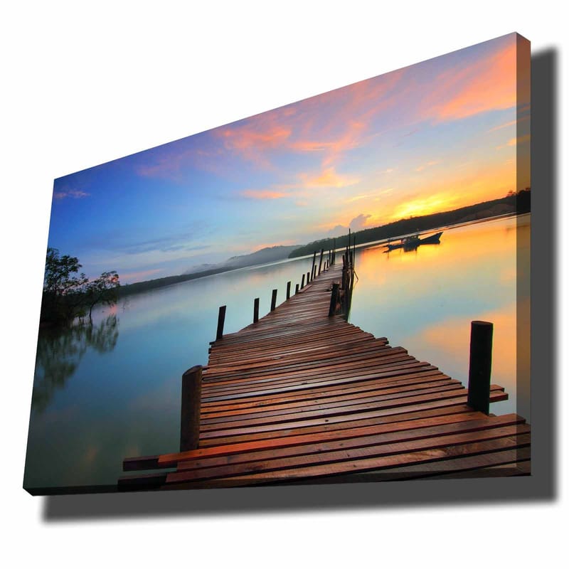 Canvastavla 70x100 cm - Vacker brygga som sträcker sig ut över en stilla sjö vid solnedgången, Blå / Orange / Brun