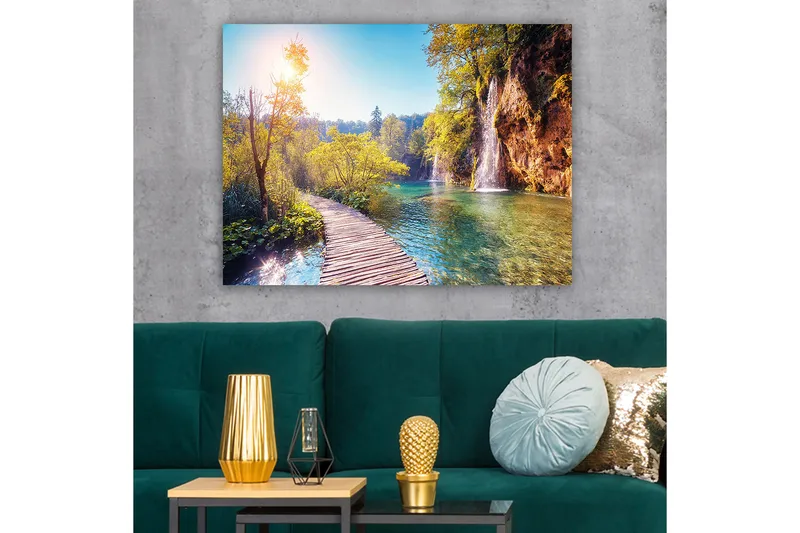 Canvastavla 70x100 cm - Vacker naturvy med en träbro som leder genom grönskande landskap och en vattenfall i bakgrunden - Grön / Blå / Gul - Inredning - Tavlor & konst - Canvastavlor