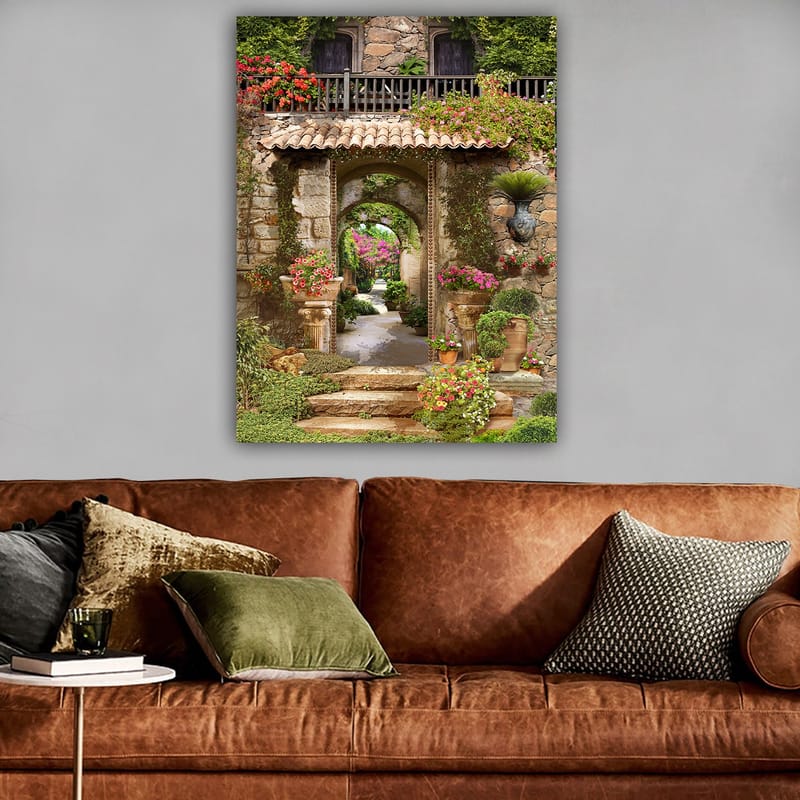 Canvastavla 70x100 cm - Vacker och grönskande trädgård med blomsterarrangemang och en stenbåge som leder in i en lummig gång - Grön / Rosa / Beige - Inredning - Tavlor & konst - Canvastavlor