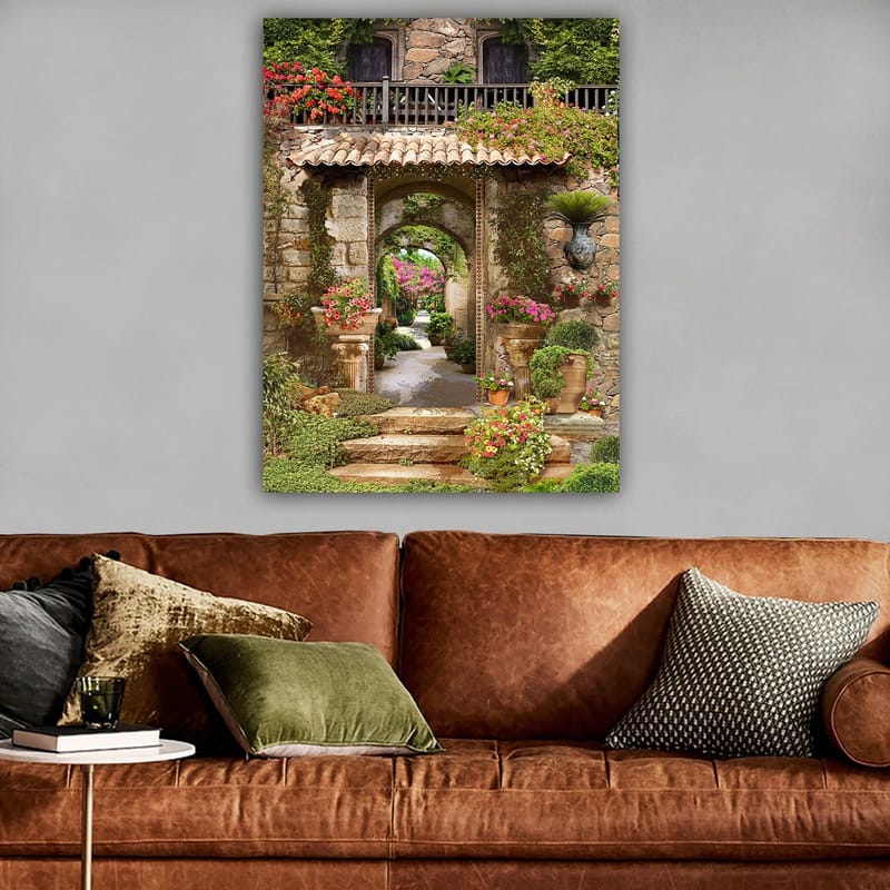 Canvastavla 70x100 cm - Vacker och grönskande trädgård med blomsterarrangemang och en stenbåge som leder in i en lummig gång - Grön / Rosa / Beige - Inredning - Tavlor & konst - Canvastavlor