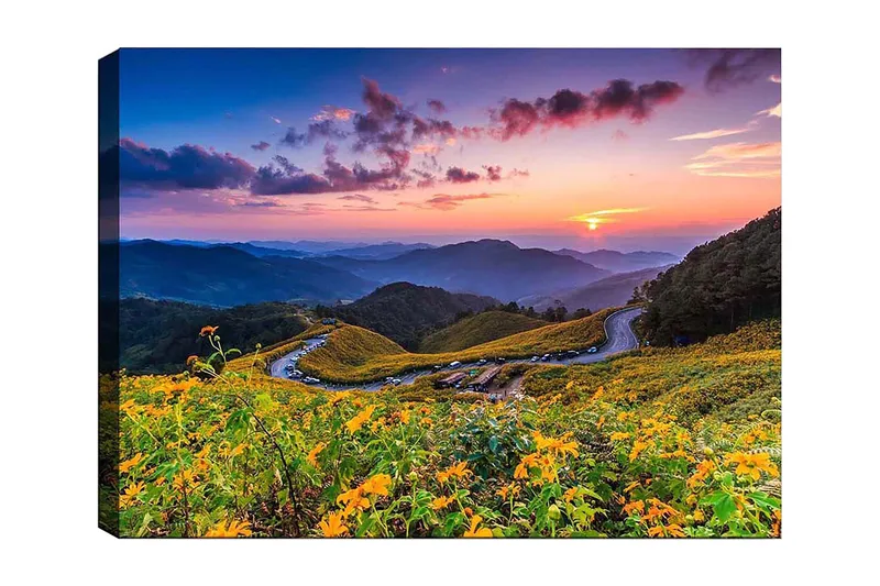 Canvastavla 70x100 cm - Vacker solnedgång över en blomstrande dal med slingrande vägar och berg i bakgrunden, Gult / Grönt / Blått