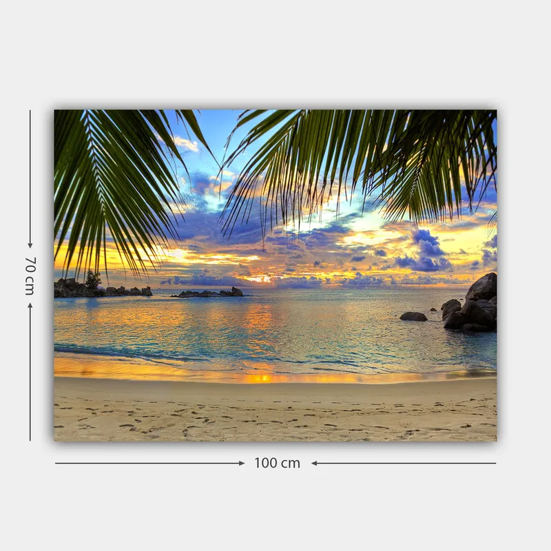 Canvastavla 70x100 cm - Vacker solnedgång över en strand med palmer som ramar in motivet - Blå / Orange / Grön - Inredning - Tavlor & konst - Canvastavlor