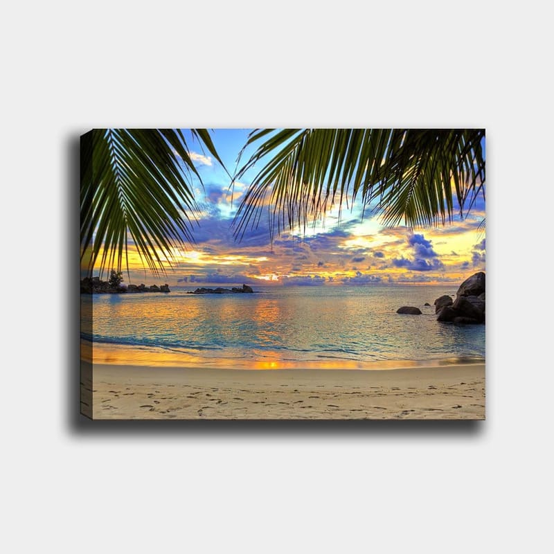 Canvastavla 70x100 cm - Vacker solnedgång över en strand med palmer som ramar in motivet, Blå / Orange / Grön