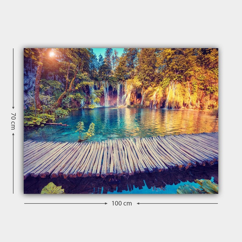 Canvastavla 70x100 cm - Vacker vattenfallsscen med klart blått vatten omgiven av frodig grönska och träd - Blå / Grön / Brun - Inredning - Tavlor & konst - Canvastavlor