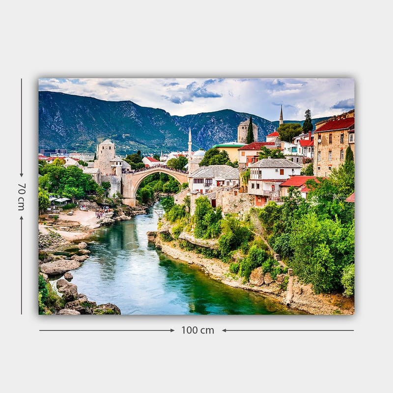 Canvastavla 70x100 cm - Vacker vy över en historisk bro som sträcker sig över en flod, omgiven av pittoreska hus och grönskande landskap - Grön / Blå / Röd - Inredning - Tavlor & konst - Canvastavlor