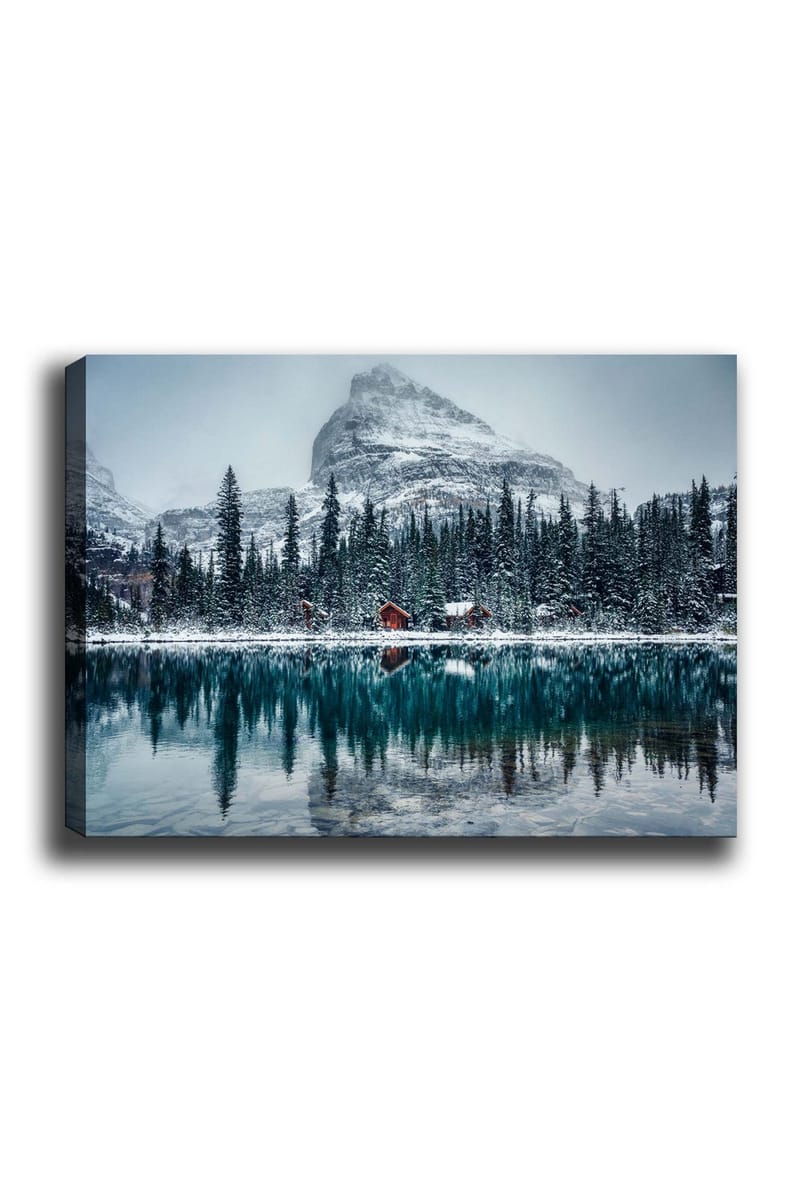 Canvastavla 70x100 cm - Vinterlandskap med snötäckta berg och en spegelblanka sjö omgiven av granar och röda stugor, Mörkgrön / Blå / Vit