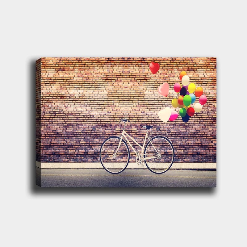 Canvastavla 70x100 cm - Vit cykel med färgglada ballonger som svävar ovanför mot en tegelvägg - Vit / Röd / Gul - Inredning - Tavlor & konst - Canvastavlor