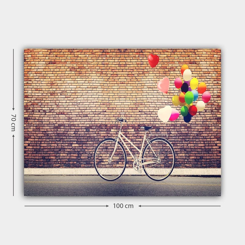 Canvastavla 70x100 cm - Vit cykel med färgglada ballonger som svävar ovanför mot en tegelvägg - Vit / Röd / Gul - Inredning - Tavlor & konst - Canvastavlor