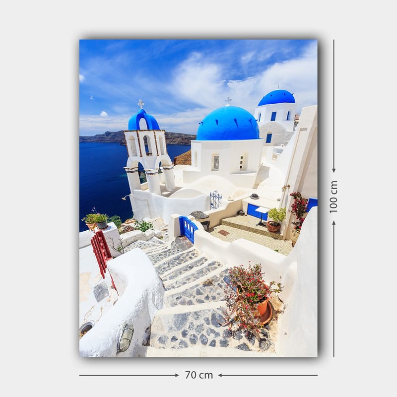 Canvastavla 70x100 cm - Pittoresk vy av vita hus med blå kupoler och en stenlagd väg i en grekisk ö-miljö - Blå / Vit - Inredning - Tavlor & konst - Canvastavlor