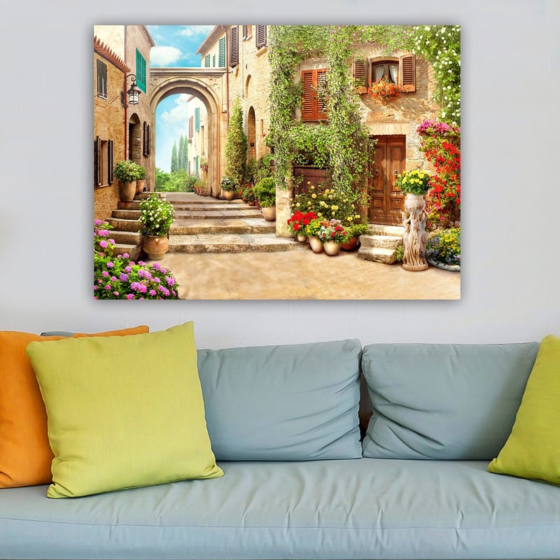 Canvastavla 70x100 cm - Pittoresk gata med blommor och grönska i en charmig bymiljö - Grön / Gul / Rosa - Inredning - Tavlor & konst - Canvastavlor