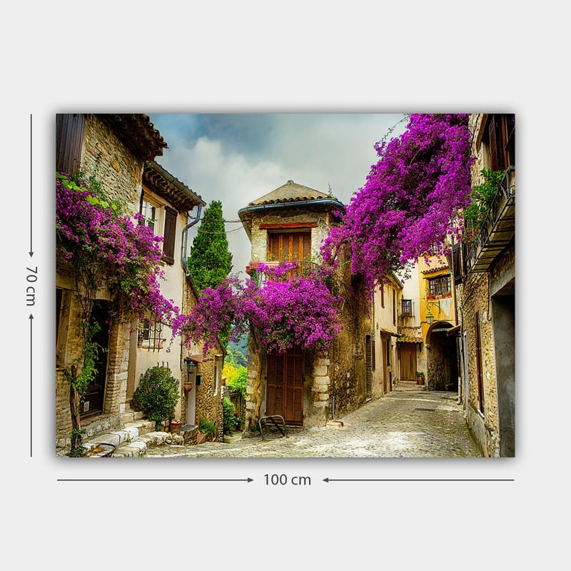 Canvastavla 70x100 cm - Pittoresk gränd omgiven av färgglada blommor i en charmig bymiljö - Lila / Grön / Beige - Inredning - Tavlor & konst - Canvastavlor