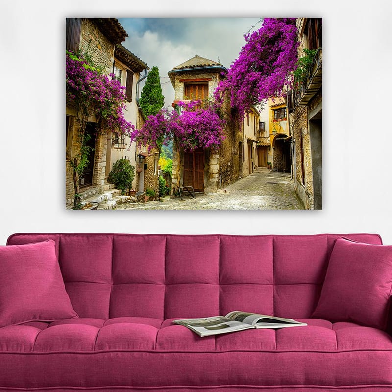 Canvastavla 70x100 cm - Pittoresk gränd omgiven av färgglada blommor i en charmig bymiljö - Lila / Grön / Beige - Inredning - Tavlor & konst - Canvastavlor