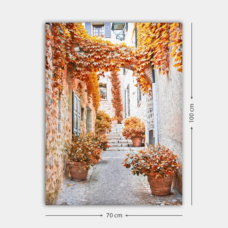 Canvastavla 70x100 cm - Pittoresk gränd omgiven av färgglada höstlöv och krukväxter - Orange / Brunt / Gult - Inredning - Tavlor & konst - Canvastavlor