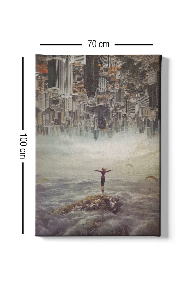 Canvastavla 70x100 cm - Person står med utsträckta armar på en klippa ovanför molnen, med en stad i bakgrunden som är upp och ner - Grå / Beige / Mörkblå - Inredning - Tavlor & konst - Canvastavlor