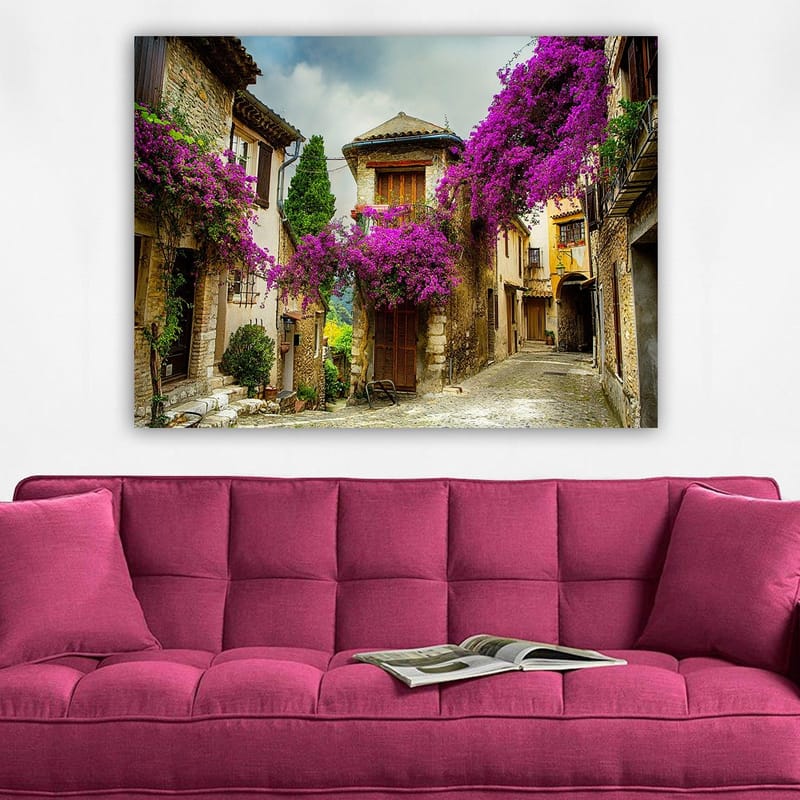 Canvastavla 70x100 cm - Pittoresk gränd omgiven av färgglada blommor i en charmig bymiljö - Lila / Grön / Beige - Inredning - Tavlor & konst - Canvastavlor